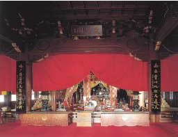 Statues of white foxes stand beside the altar to Toyokawa Dakini Shinten.