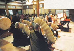 Orações de ano novo. Os monges manipulam sutras dobrados em forma de sanfona em arcos livres.